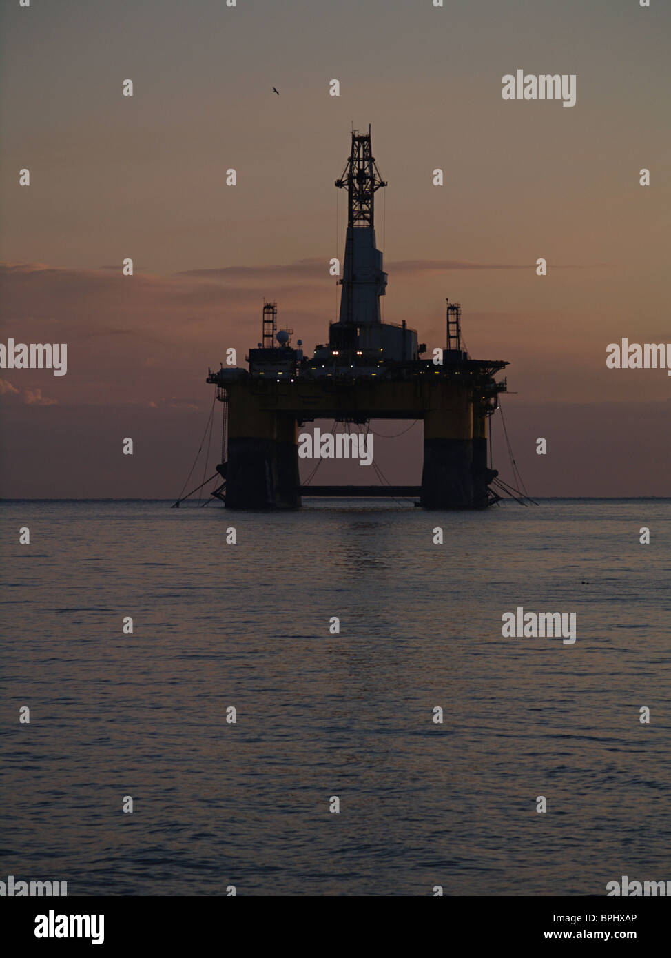 Die Transocean Rather, semi-submersible Ölplattform ist gegen die Morgenröte, Cromarty Firth, Schottland Silhouette. Stockfoto
