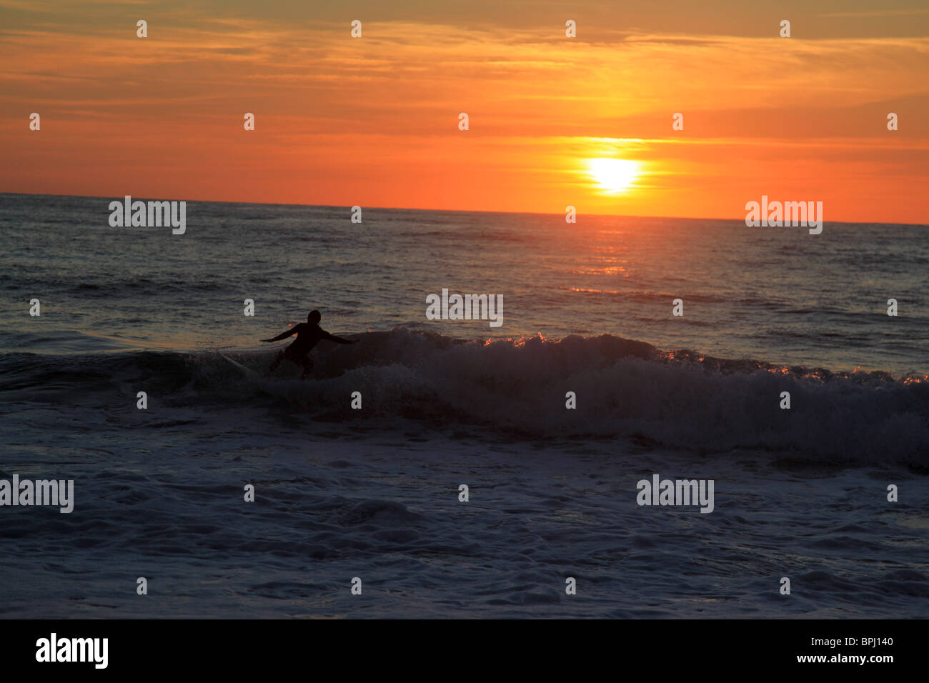 Surfeur Qui Pratique Sohn Sport au Couché de soleil Stockfoto