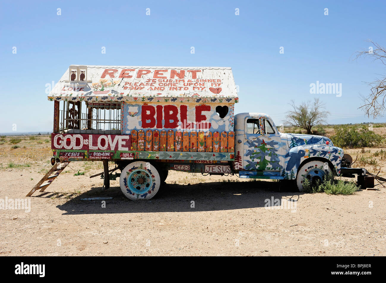 Oldtimer LKW mit nach Hause auf Rückseite bemalt mit religiösen Parolen, befindet sich am Berg Heil, Slab City, Niland, Kalifornien, USA. Stockfoto