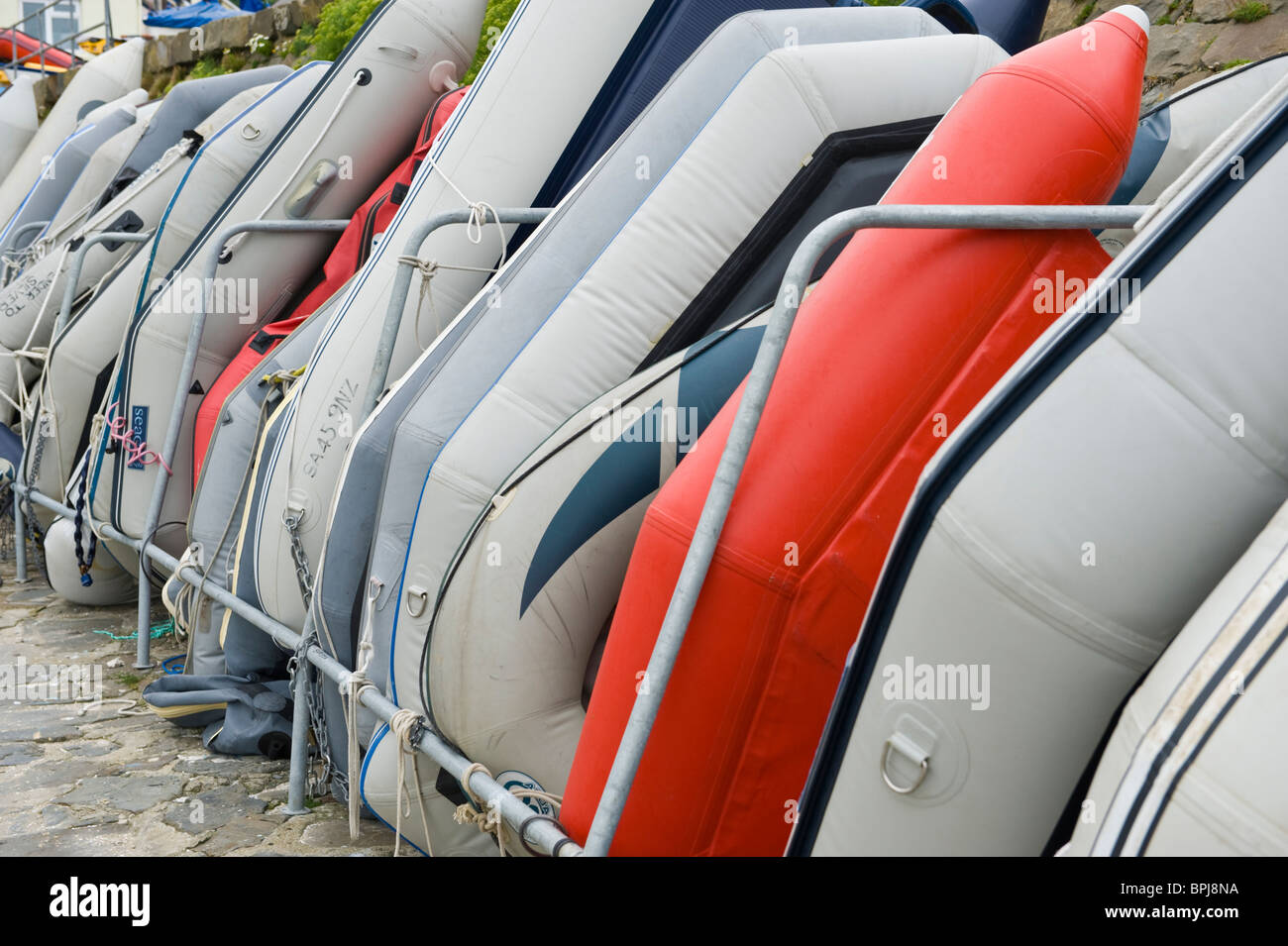 Schlauchboot-Angebote, die gegen die Hafenmauer im Urlaub am Meer Stadt des neuen Kai Ceredigion West Wales UK gespeichert Stockfoto