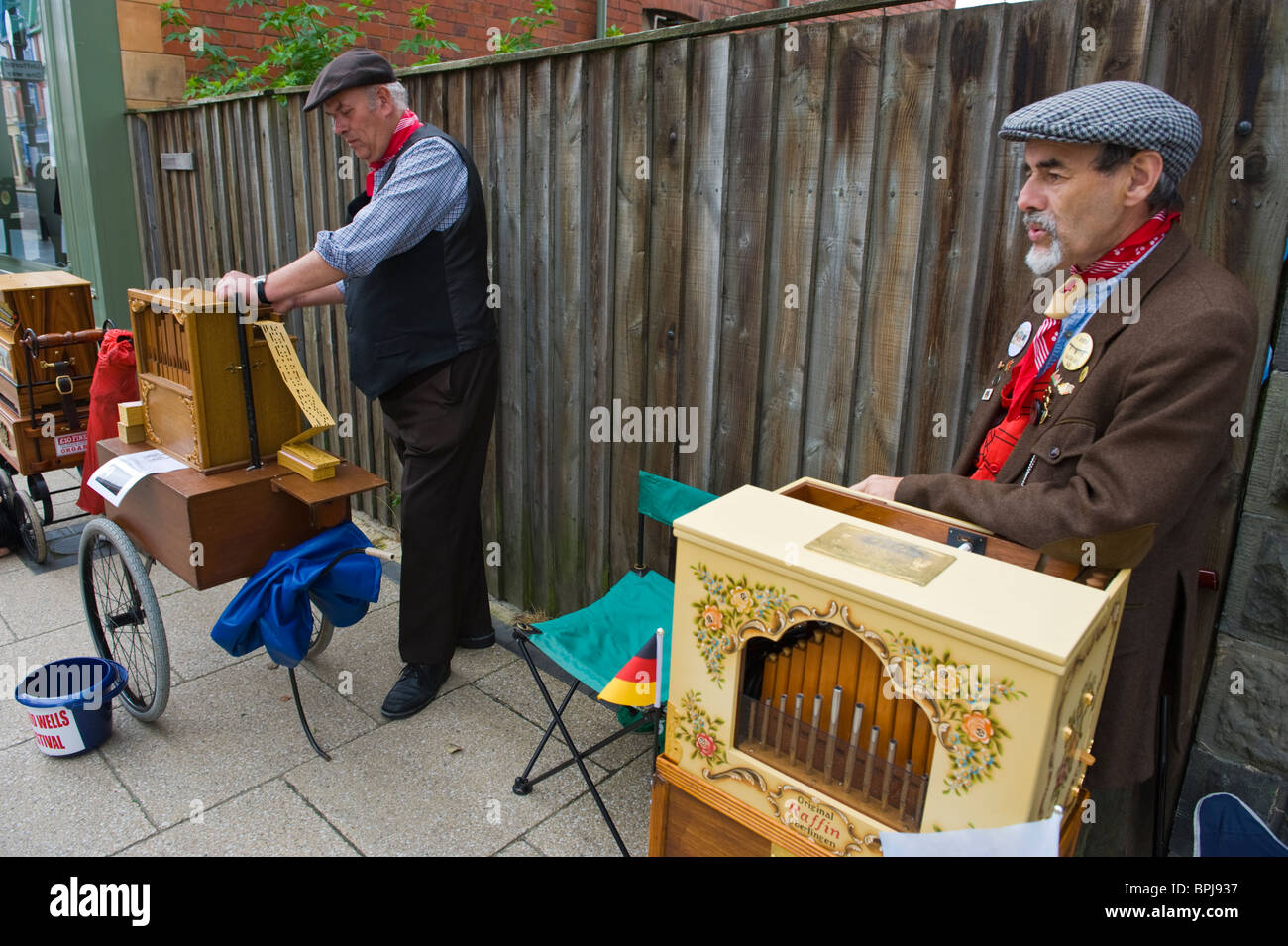Orgel-Schleifmaschinen in historischen Kostümen spielen Drehorgeln auf dem viktorianischen Festival in Llandrindod Wells Powys Mid Wales UK Stockfoto