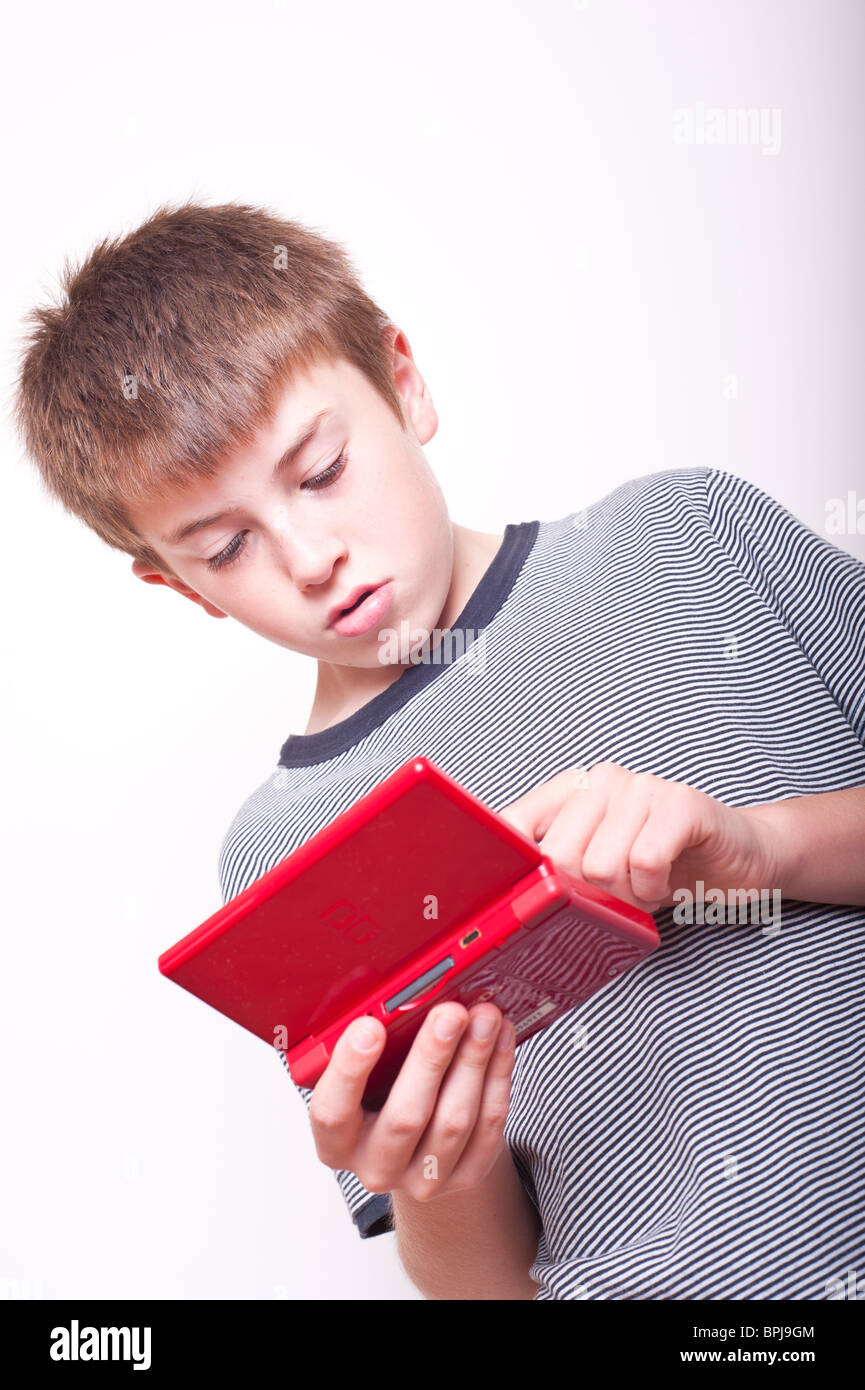 Ein MODEL Release Bild eines 10 Jahre alten Jungen mit einer Nintendo DS Handheld-Spielekonsole im Studio spielen Stockfoto