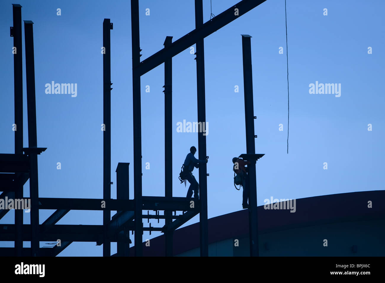 Bauarbeiter arbeiten mit eisernen Balken, einen Wolkenkratzer bauen. Stockfoto
