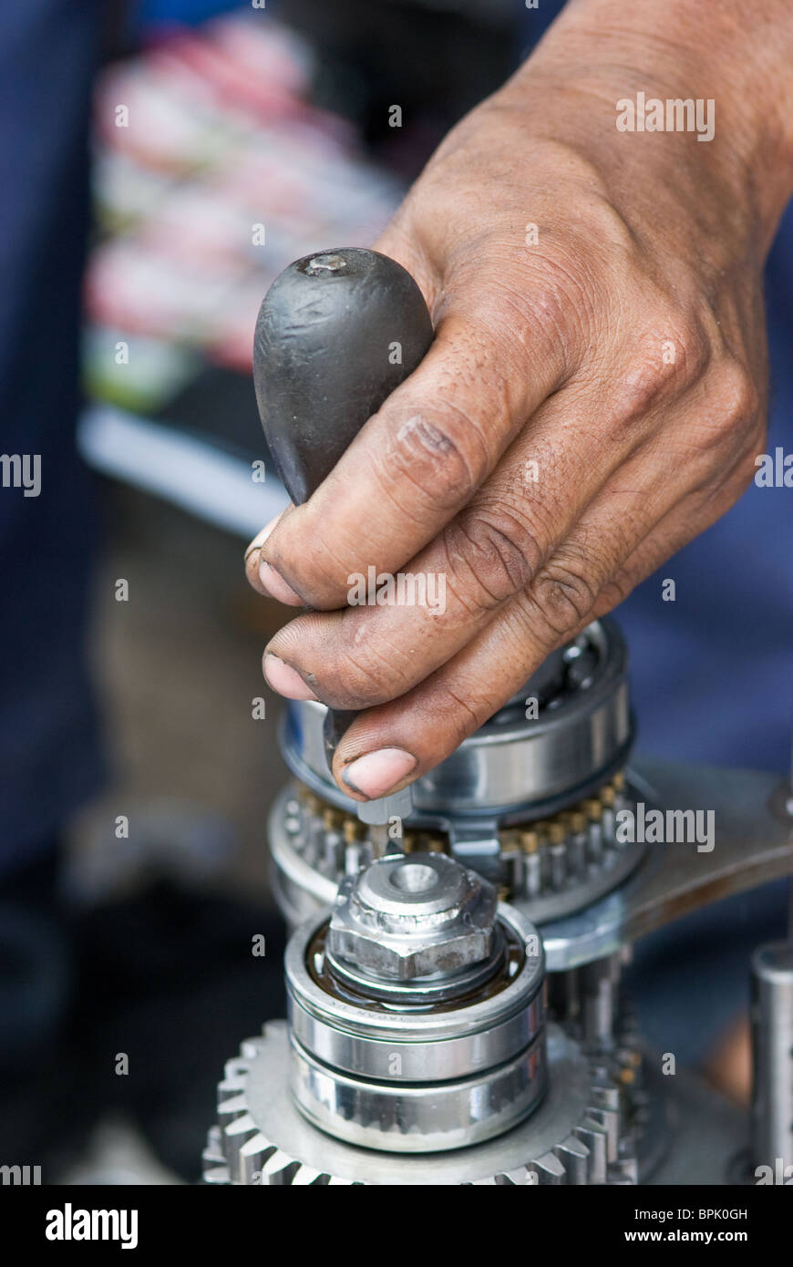 Hand des Kfz-Mechaniker eine Getriebe zu reparieren. Geringe Schärfentiefe mit der Hand im Fokus. Stockfoto