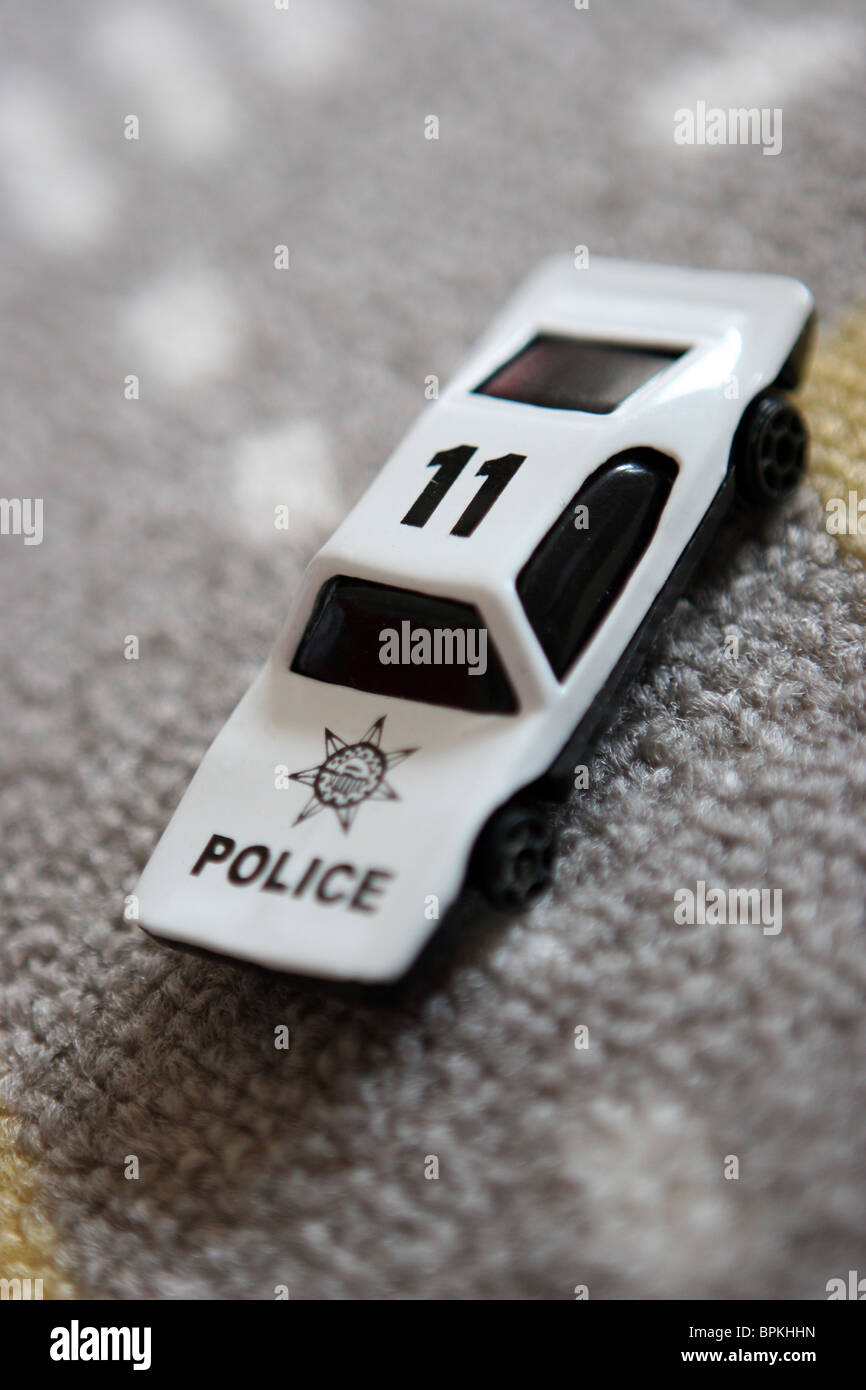 Weißer Spielzeug Polizeiauto auf Teppich Stockfoto