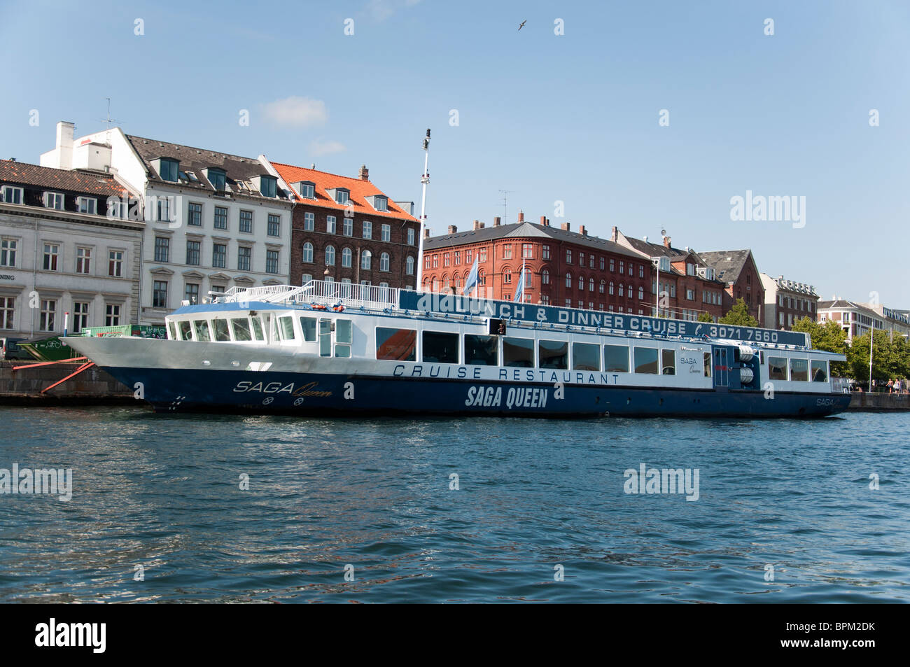 Ein Blick auf die Gebäude und einen Kanal Kreuzfahrt Boot am Nyhavn Kanal in Kopenhagen, Dänemark. Stockfoto