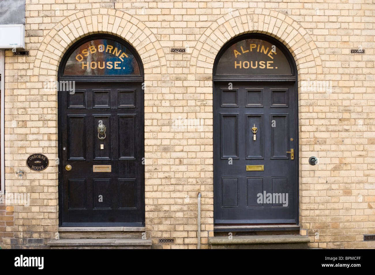 2 dunkle viktorianische getäfelten vorderen Türen mit Messing Briefkasten Klopfer und Oberlicht aus Backstein gebaut Häuser mit Schritten Stockfoto