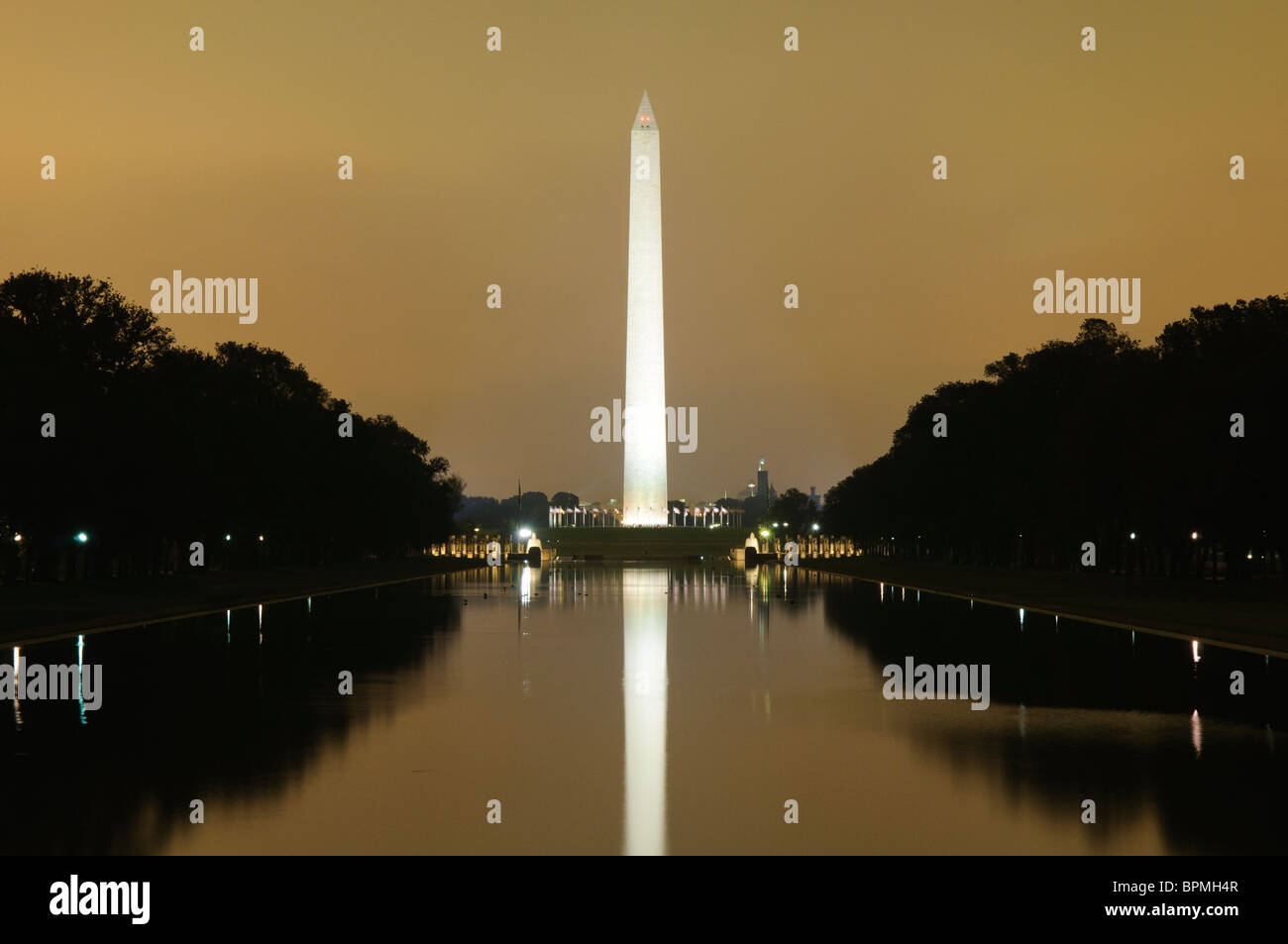 WASHINGTON DC, USA - Washington Monument auf der reflektierenden Pool wider, mit orangen Schein der Lichter der Stadt aus niedrigen Wolken Stockfoto