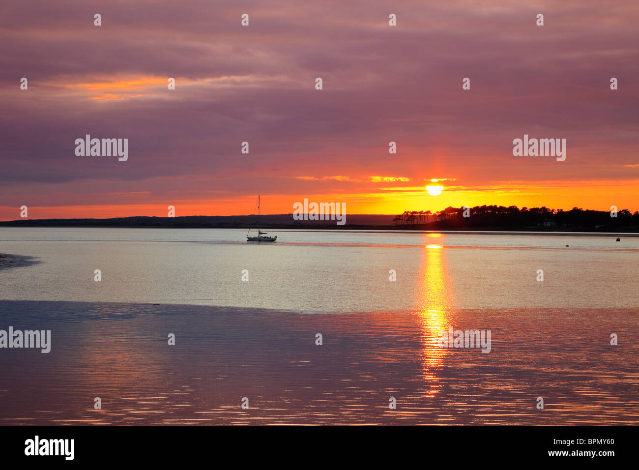 Sonnenuntergang über der Insel Anglesey in der Menaistraße bei Sonnenuntergang von Caernarfon, Gwynedd, Wales, Großbritannien, Großbritannien Stockfoto