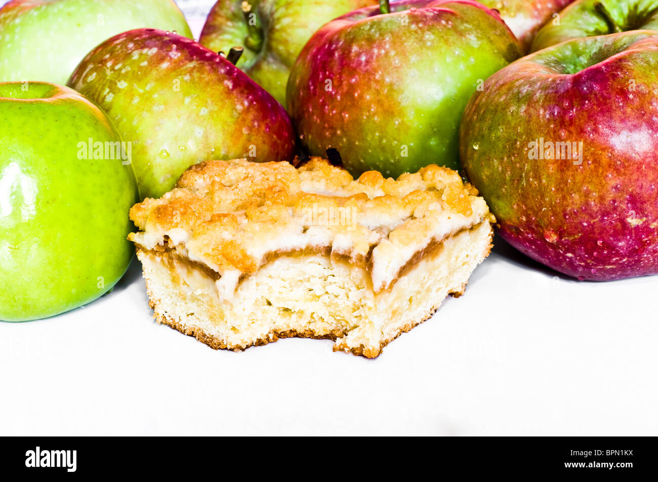 Gebissen Apfelkuchen und rote und grüne Äpfel auf weißem Hintergrund Stockfoto