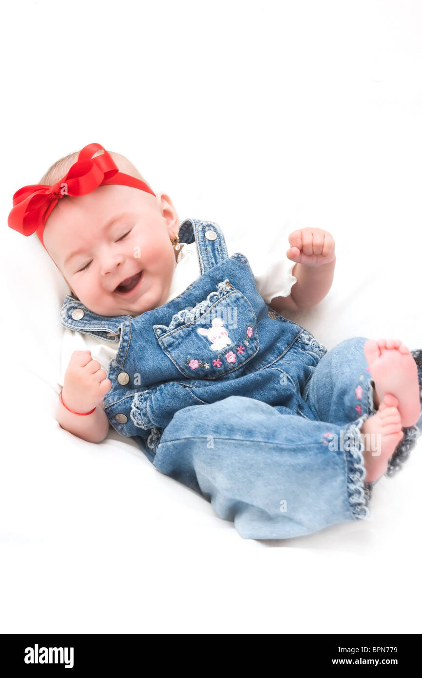 Babymädchen gekleidet in Jeans, die laut lachen. Stockfoto