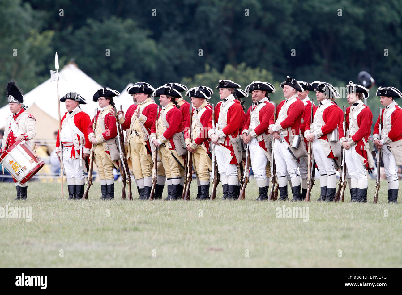 Rotröcke aus dem amerikanischen Unabhängigkeitskrieg 1775-1783. Brown Bess Musketen, Schnauze laden Steinschloss glatte Bohrungen Festival Geschichte 2010, Kelmarsh Hall, Northamptonshire. Re-Anactors erleben Sie britische Geschichte von den Römern bis zum zweiten Weltkrieg Stockfoto