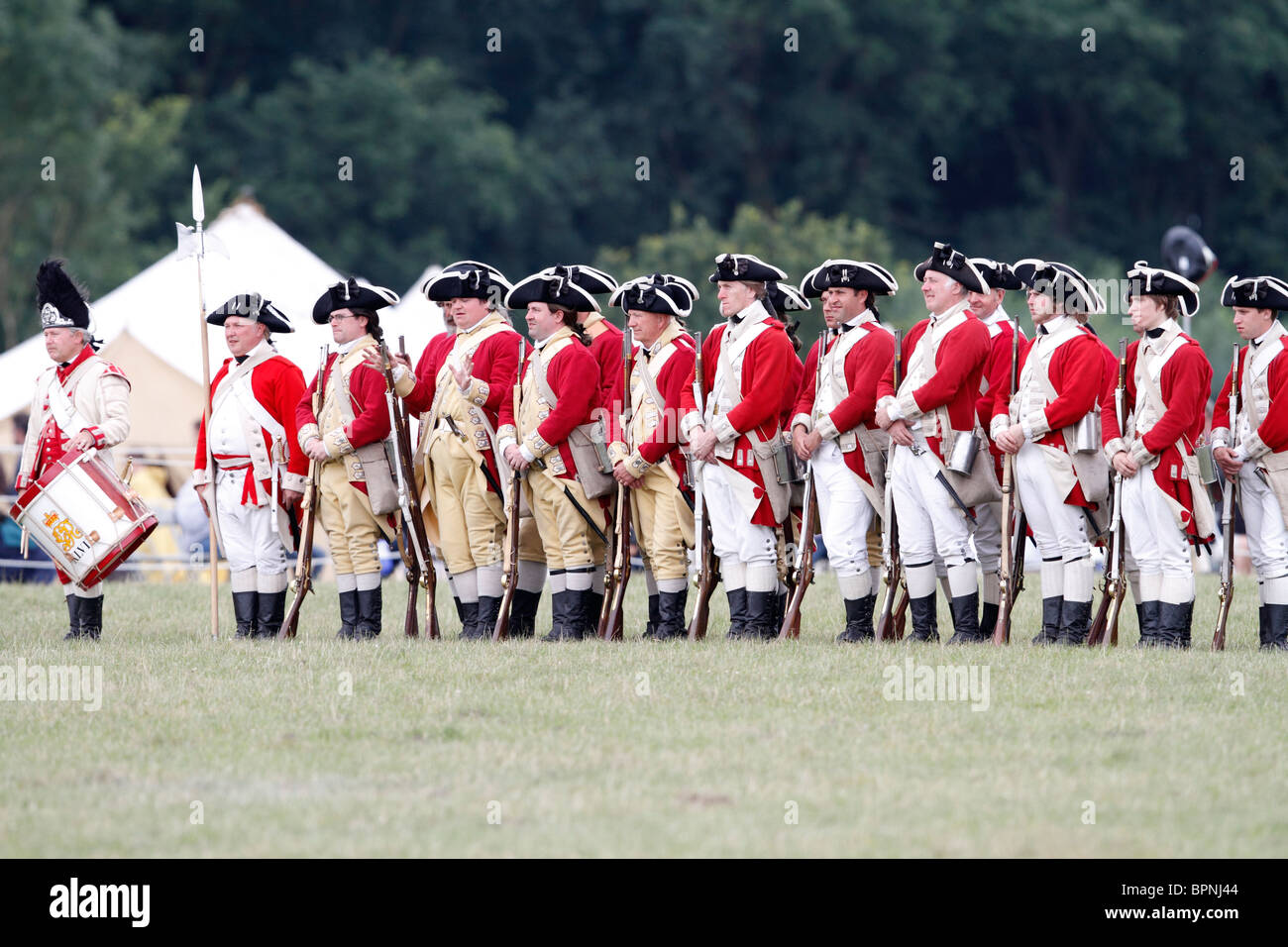 Rotröcke aus dem amerikanischen Unabhängigkeitskrieg 1775-1783. Brown Bess Musketen, Schnauze laden Steinschloss glatte Bohrungen Festival Geschichte 2010, Kelmarsh Hall, Northamptonshire. Re-Anactors erleben Sie britische Geschichte von den Römern bis zum zweiten Weltkrieg Stockfoto