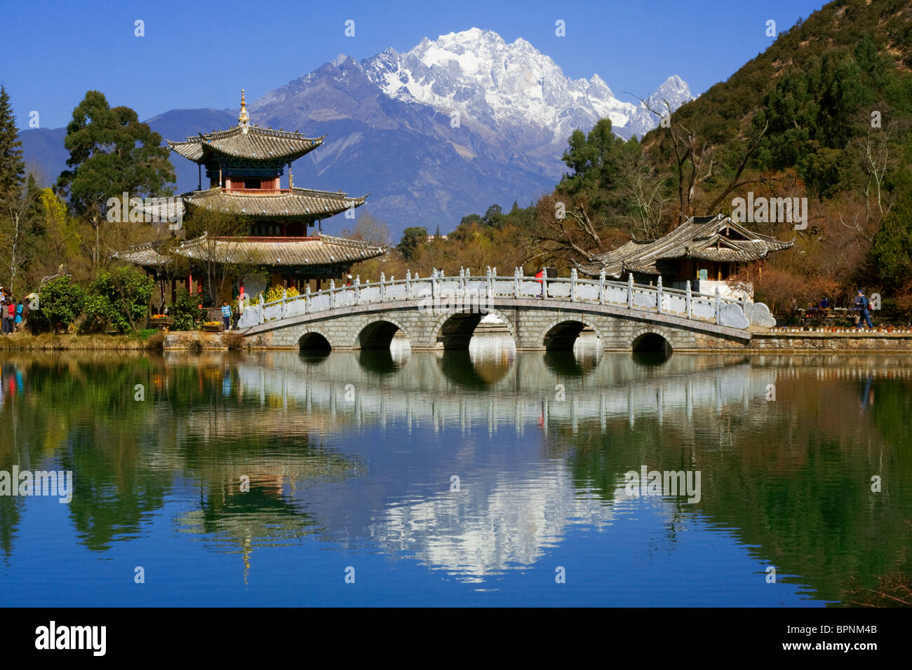 Pagode und Brücke spiegelt sich auf Black Dragon Pool vor Jade Dragon Snow Mountain, Lijang, Yunnan, China Stockfoto