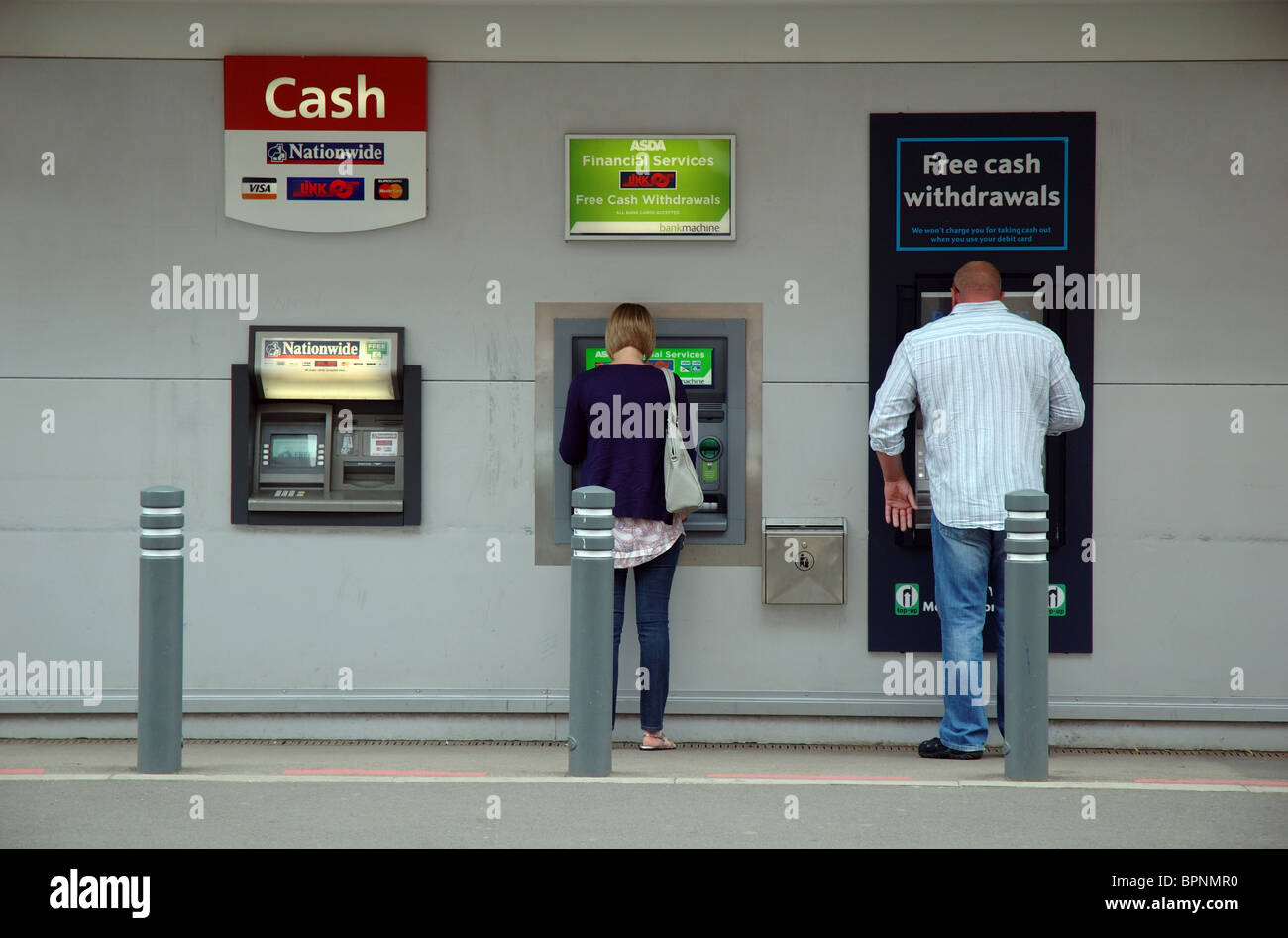 Mann und Frau mit Geldautomaten, ASDA Supermarkt, Rushden, Northamptonshire, England, UK Stockfoto