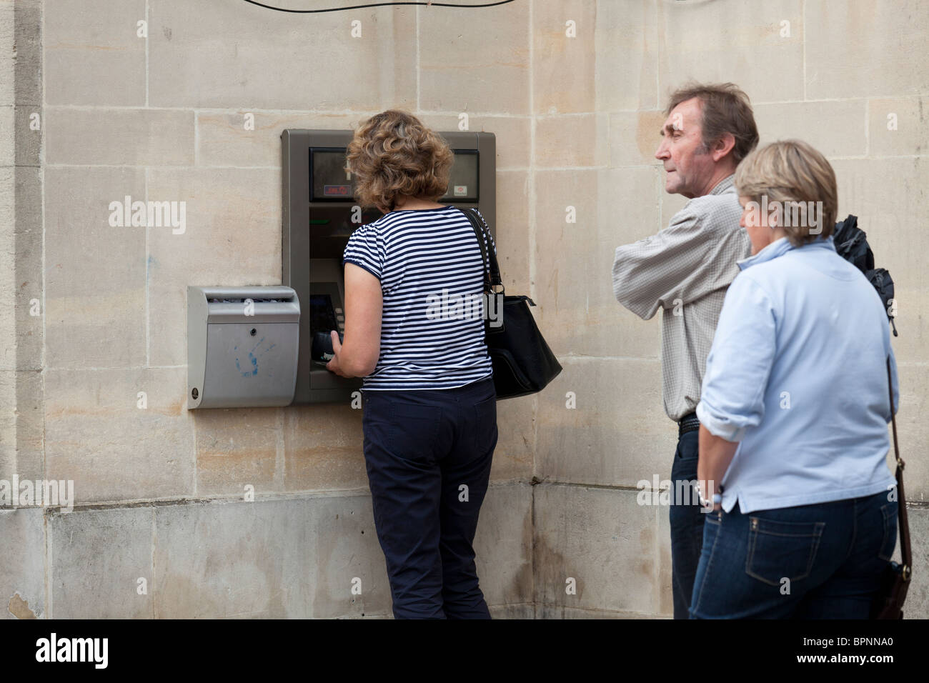 Schlange stehen und immer Geld aus Geldautomaten Loch in der Wand Geldmaschinen Stockfoto