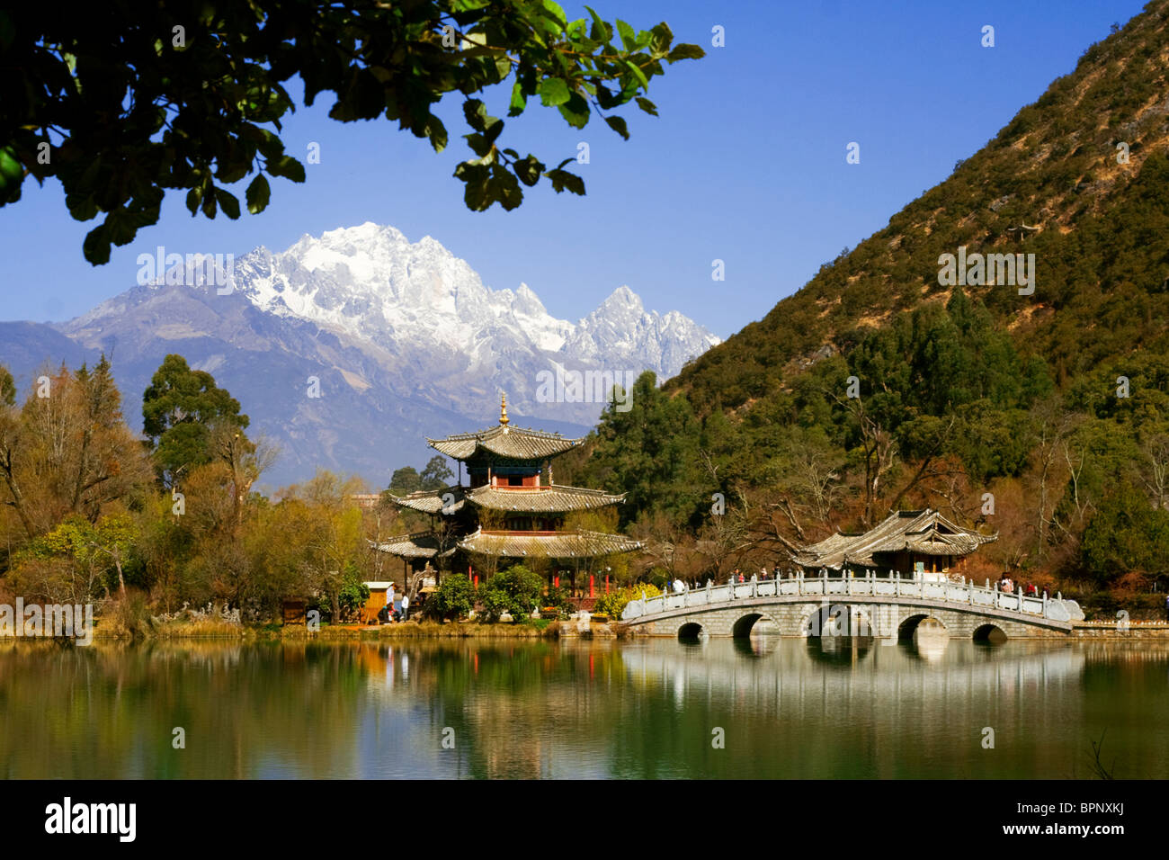Pagode und Brücke spiegelt sich auf Black Dragon Pool vor Jade Dragon Snow Mountain, Lijang, Yunnan, China Stockfoto
