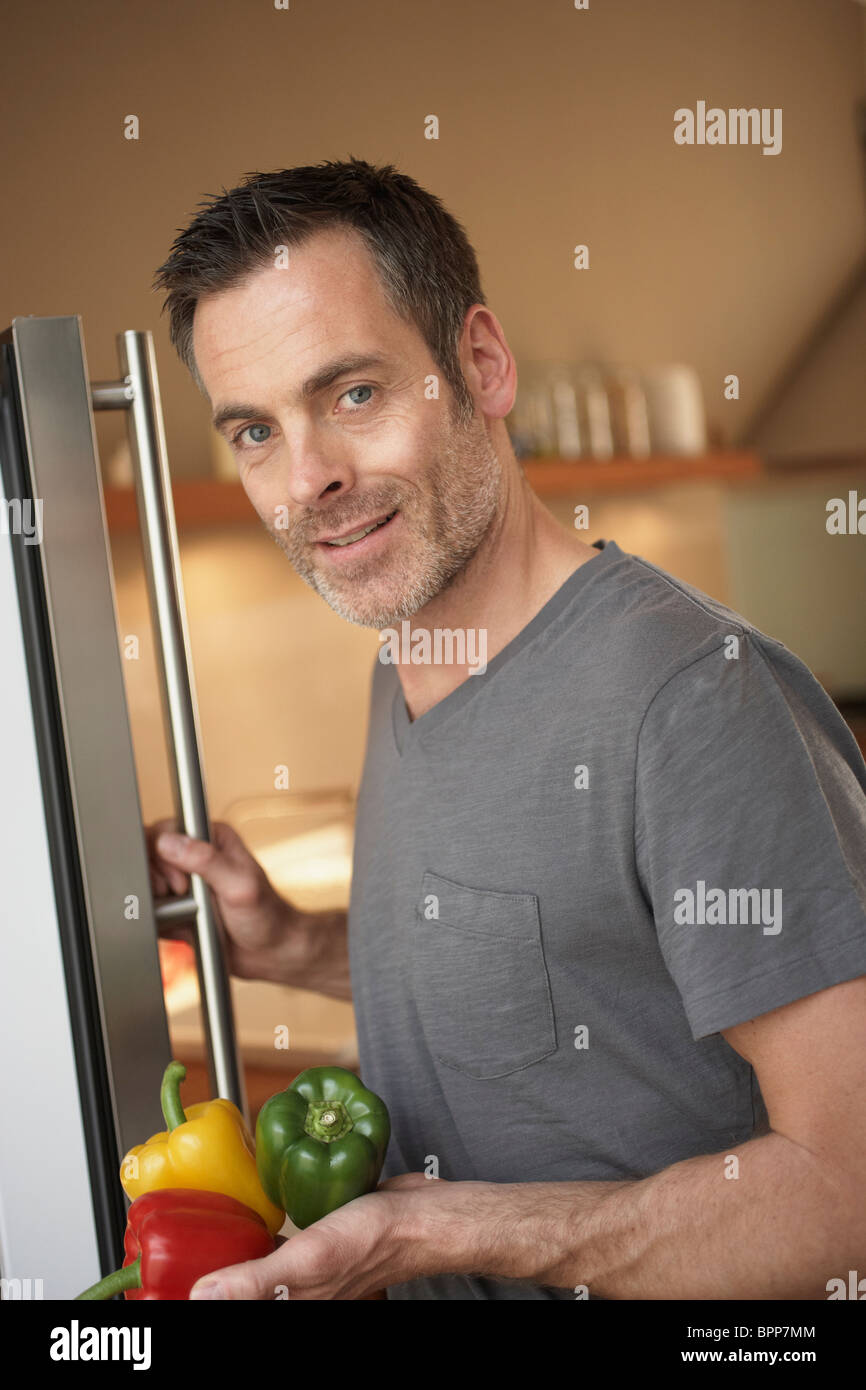 Mann steht vor Kühlschrank Stockfoto