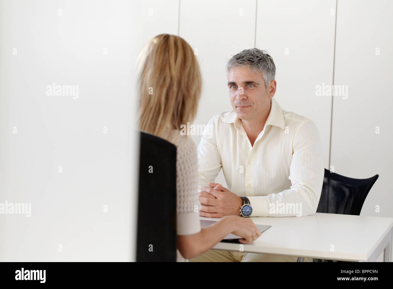 Ältere Mann interviewt junge Frau Stockfoto