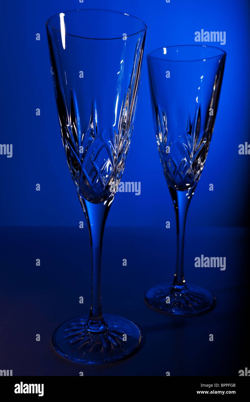 Studioaufnahme von zwei Kristall Champagner Flöten auf blauem Grund Stockfoto