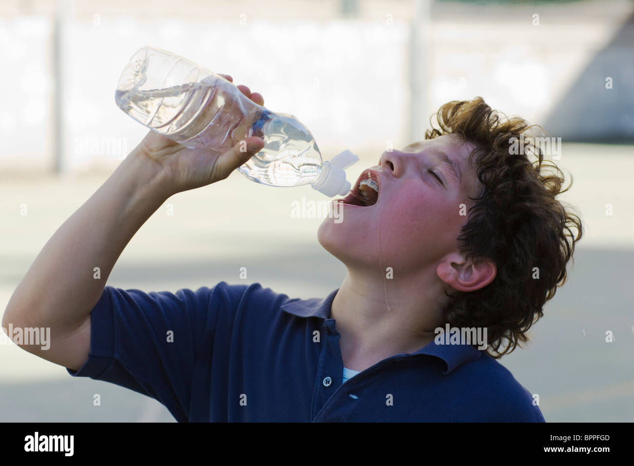 Junge Trinkwasser aus der Flasche Stockfoto
