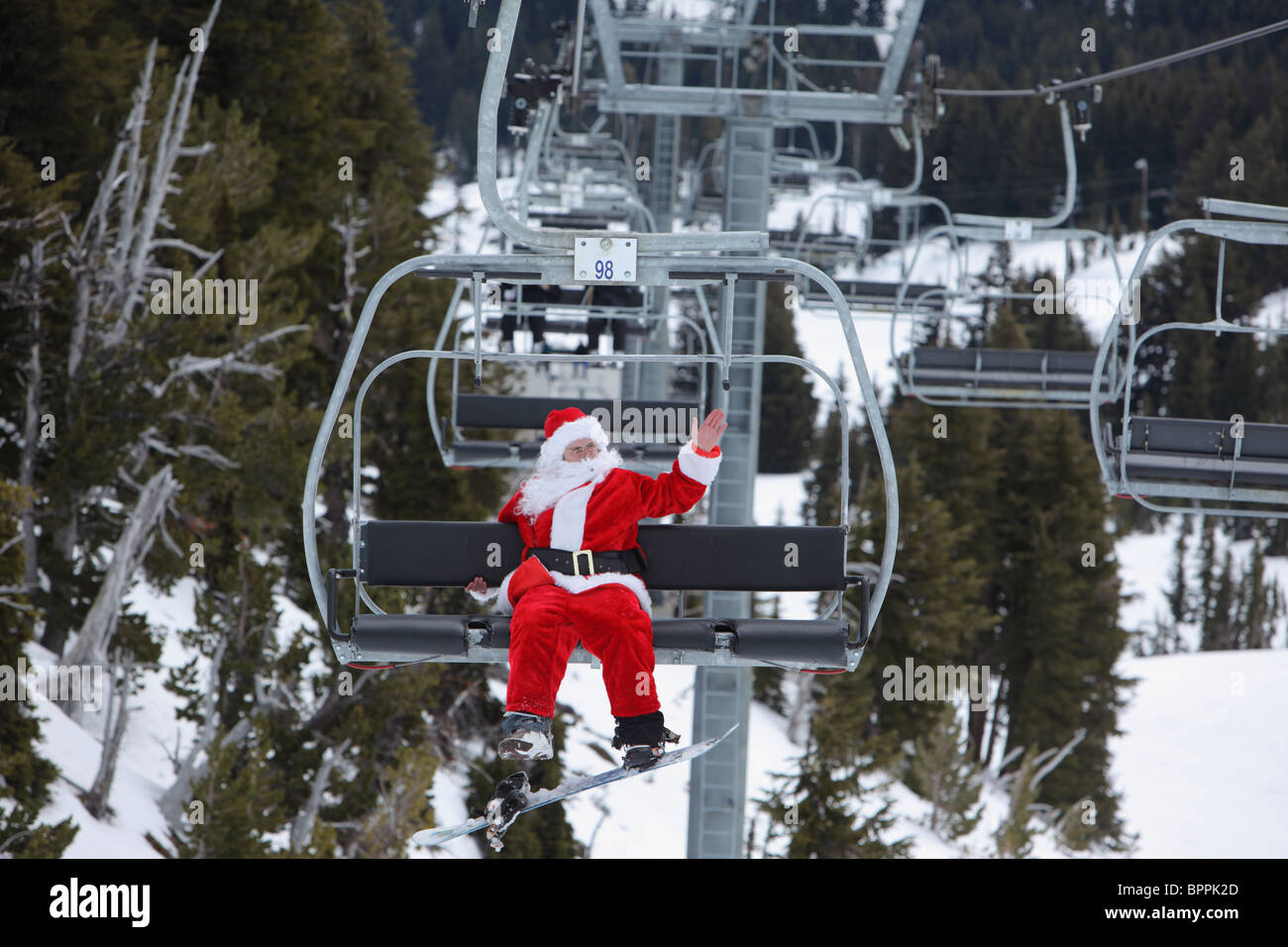 Santa Claus mit Snowboard am Skilift Stockfoto