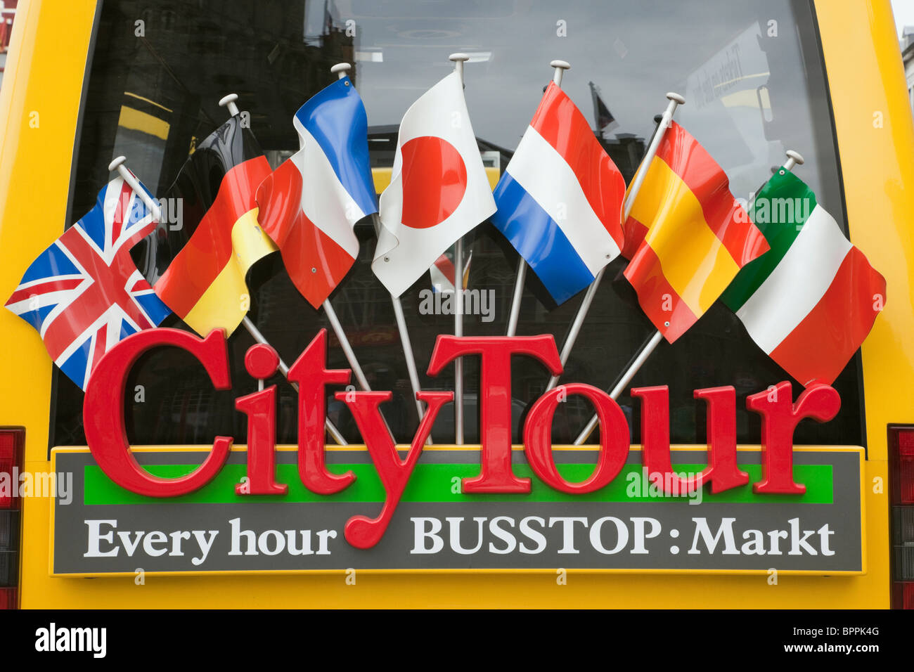 Weiter hinten eine City Tour Bus mit internationalen Fahnen geschmückt. Markt, Brügge, Belgien, Europa. Stockfoto