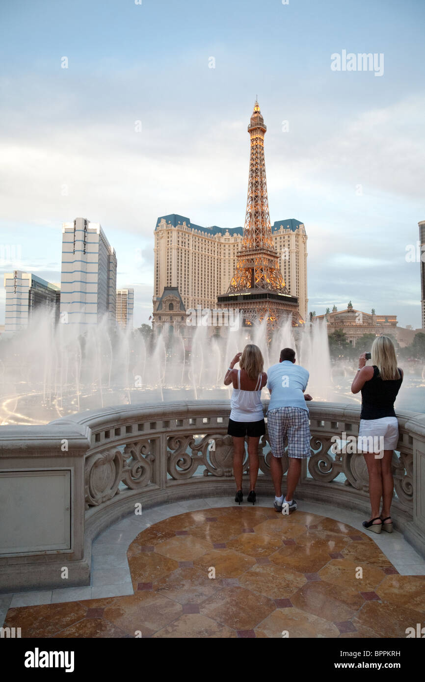 Leute beobachten die Springbrunnen des Bellagio Hotels gesehen vor dem Hintergrund des Paris Hotels, Las Vegas, Nevada, USA Stockfoto