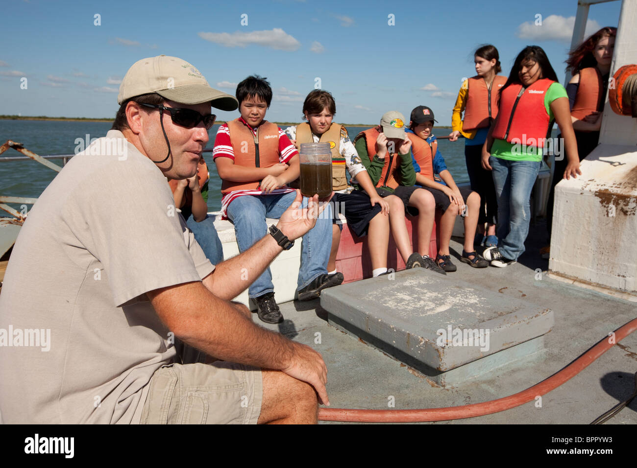 Meeresbiologe zeigt Wasserprobe für Mittelschüler / innen an Bord bei Klasse Exkursion im Golf von Mexiko Stockfoto