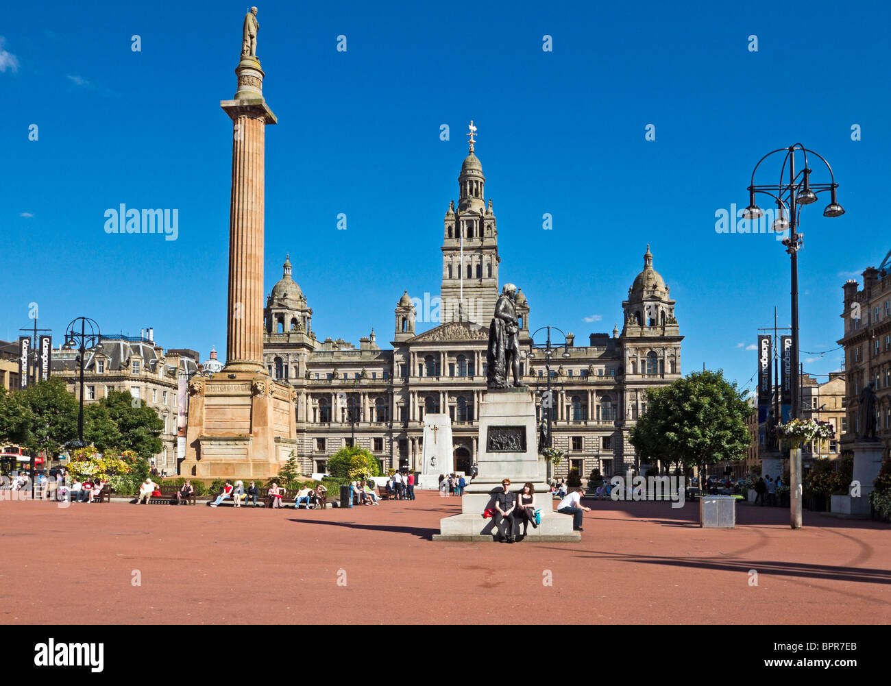 George Square im Zentrum von Glasgow mit Sir Walter Scott Statue links und Robert Burns Statue rechts und City Chambers hinten Stockfoto
