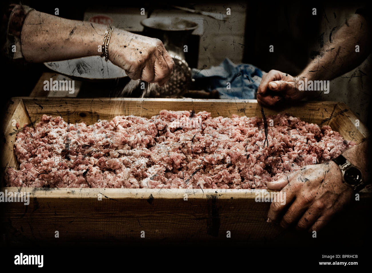 Eine Frau die Hackfleisch vom Schwein Salz aufsetzen. Stockfoto