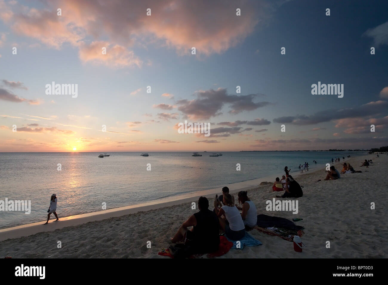 Menschen genießen den Sonnenuntergang auf der Seven Mile Beach, Grand Cayman Island Stockfoto