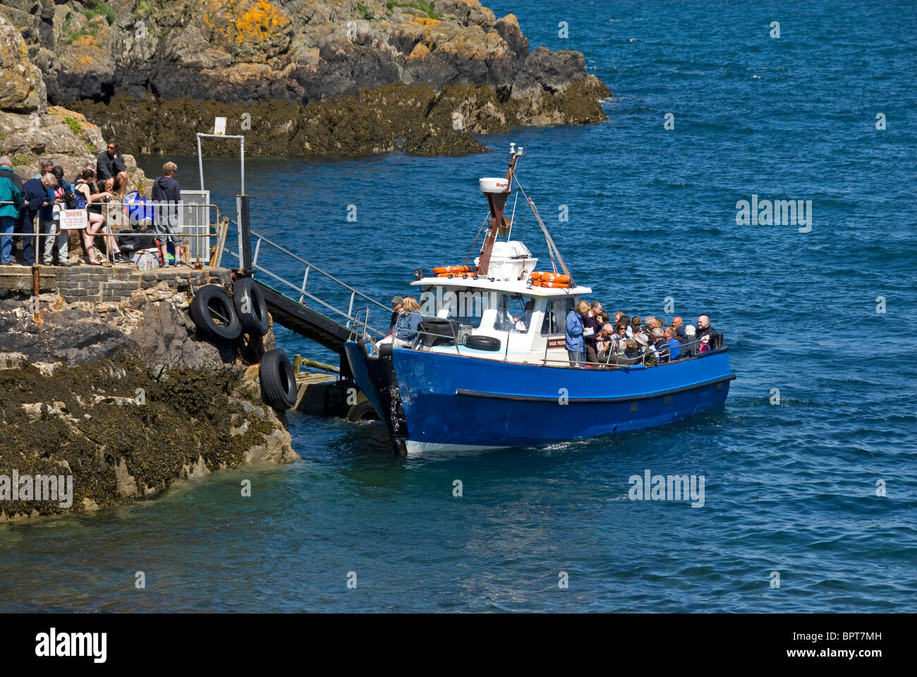 Menschen, die kleine blaue Boot, Martins Haven, Pembrokeshire, Wales Stockfoto