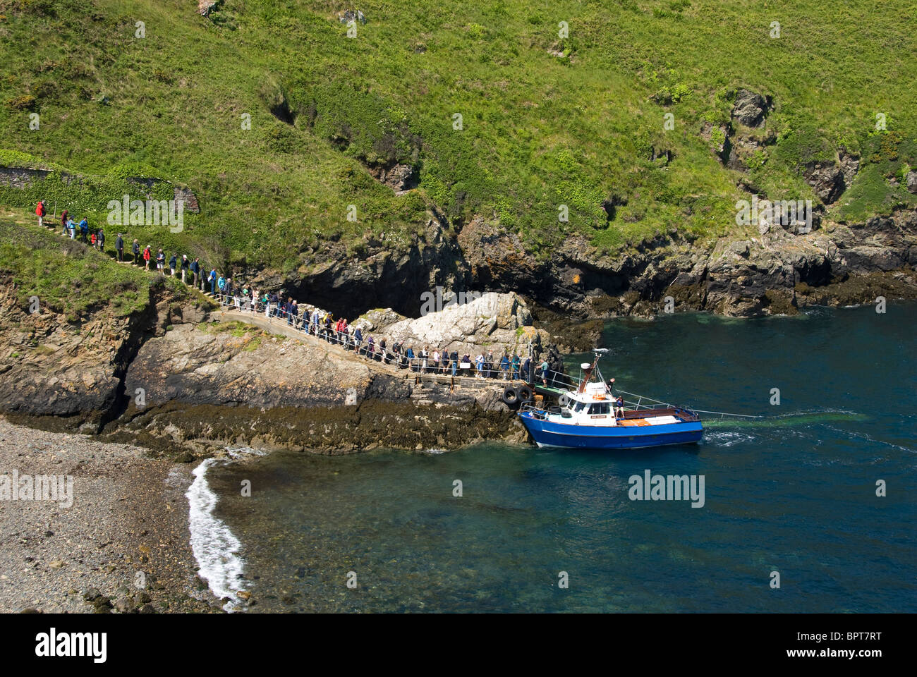 Schlange von Menschen, die kleine blaue Boot, Martins Haven, Pembrokeshire, Wales Stockfoto