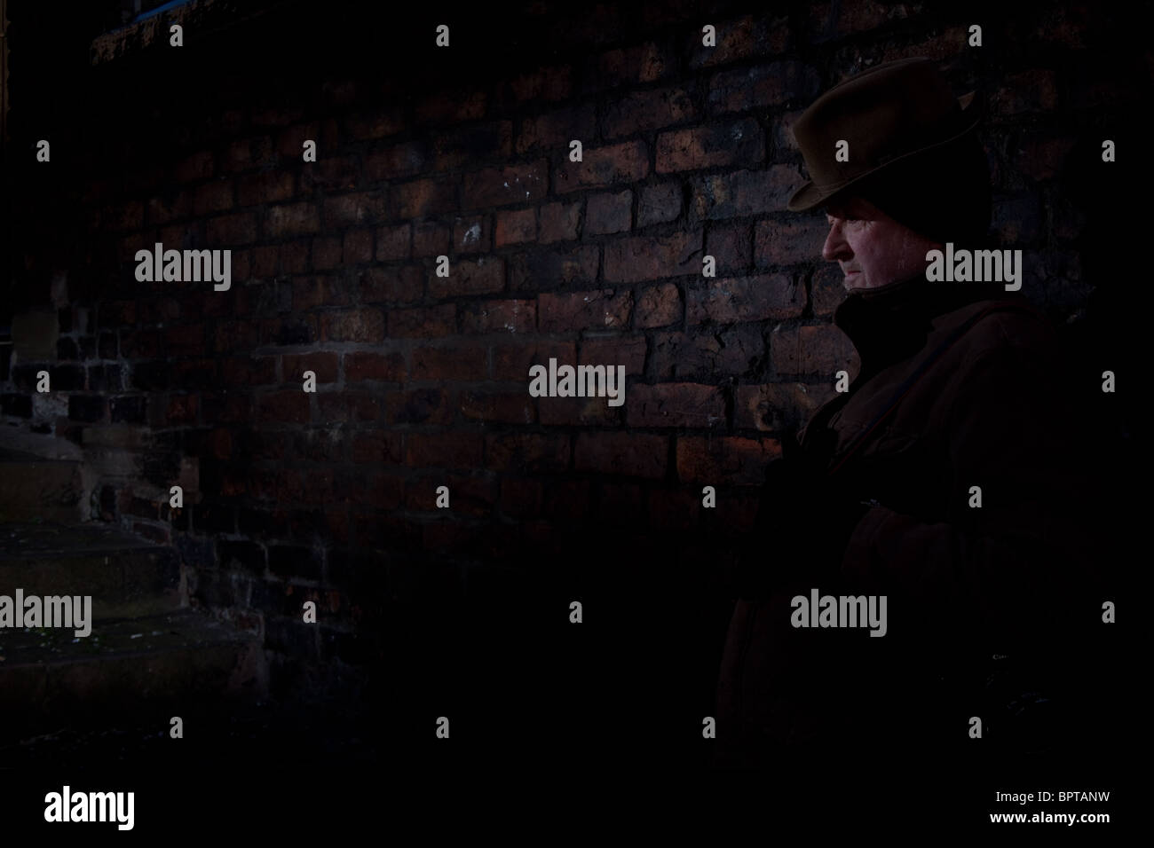 Film Noir Darstellung einen ruhigen und gefährlichen Mann wartet in einer dunklen Gasse. Stockfoto