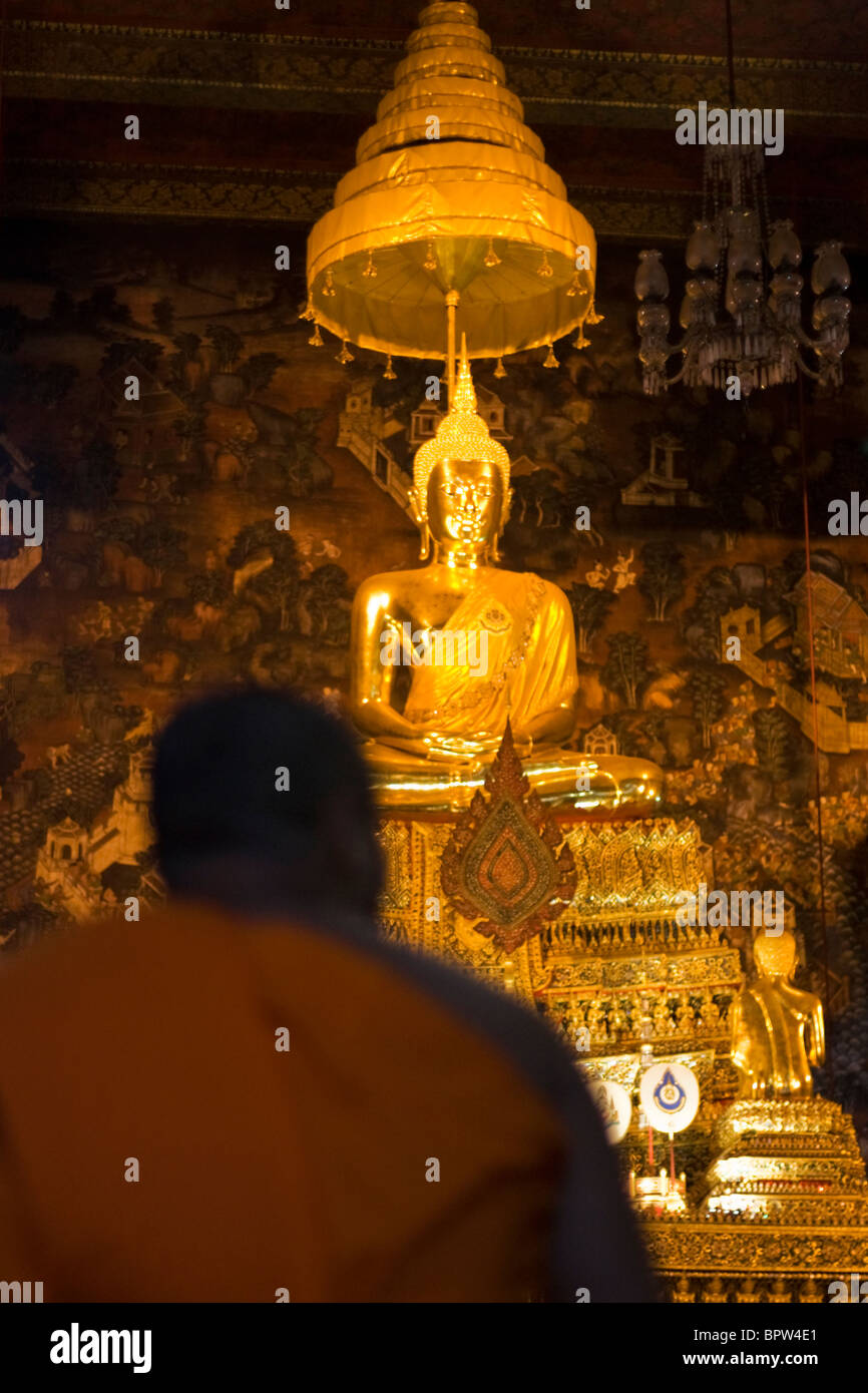 Ein Mönch kniet vor einer Buddha-Statue im Wat Po, Grand Palace, Bangkok, Thailand. Indochina. Südost-Asien. Januar 2010 Stockfoto