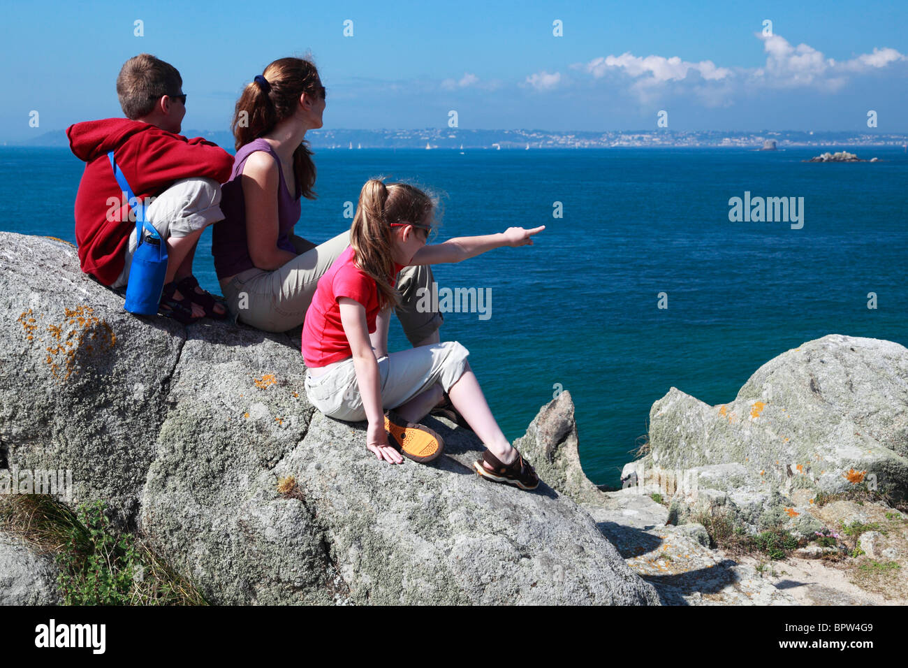 Eine Familie genießt die herrliche Aussicht von Guernsey von Herm in der englischen Kanalinseln. Stockfoto
