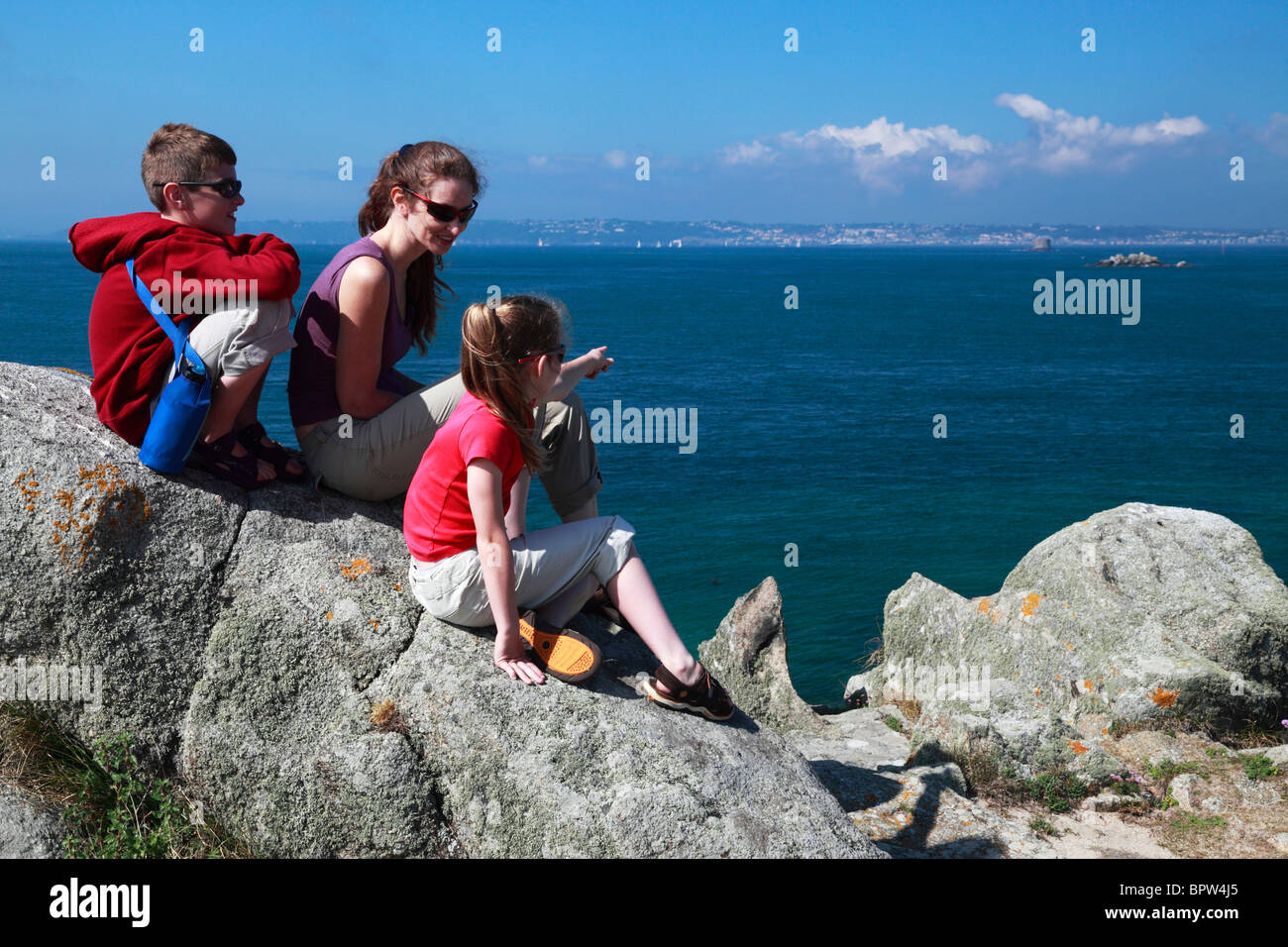 Eine Familie genießt die herrliche Aussicht von Guernsey von Herm in der englischen Kanalinseln. Stockfoto