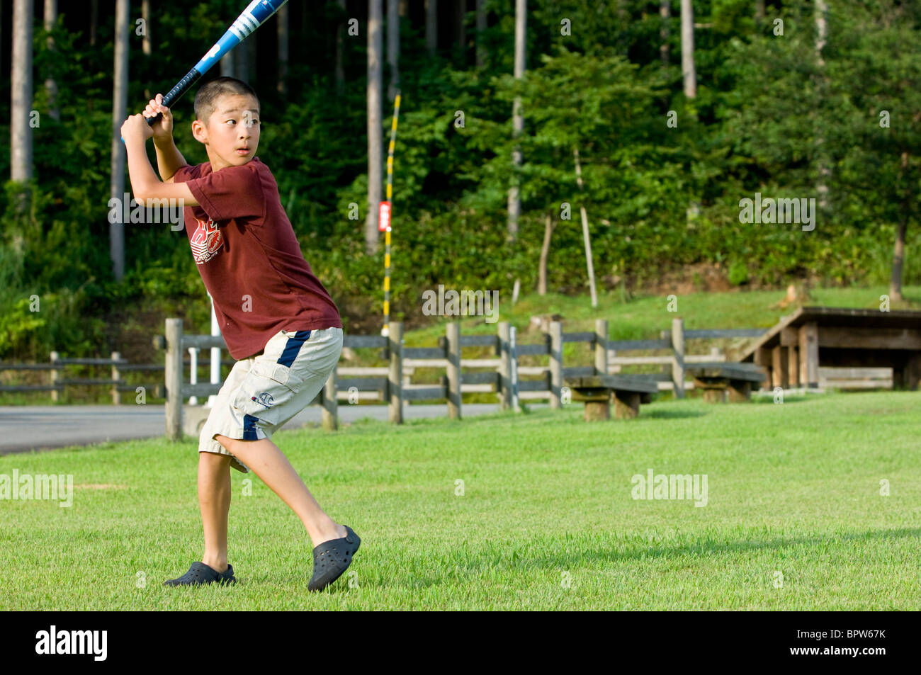 Japanische junge bereitet sich auf einen Baseballschläger in einem Park zu schwingen Stockfoto