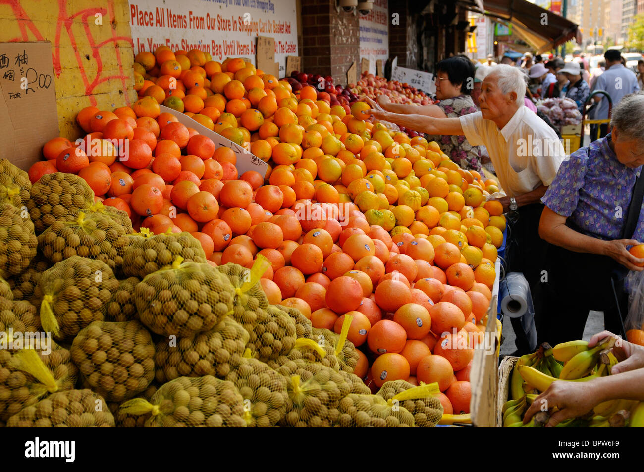 Kunden Kommissionierung Früchte auf einem Bürgersteig Lebensmittelgeschäft in Chinatown Toronto Stockfoto