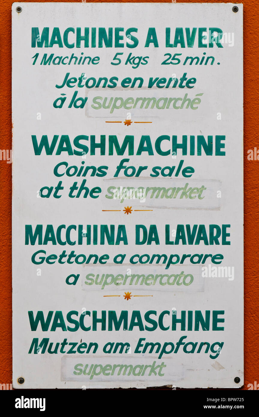 Mehrsprachige Zeichen für Waschtrockner auf ein Campingplatz mit der Meldung, die Münzen stehen zum Verkauf im Supermarkt Stockfoto