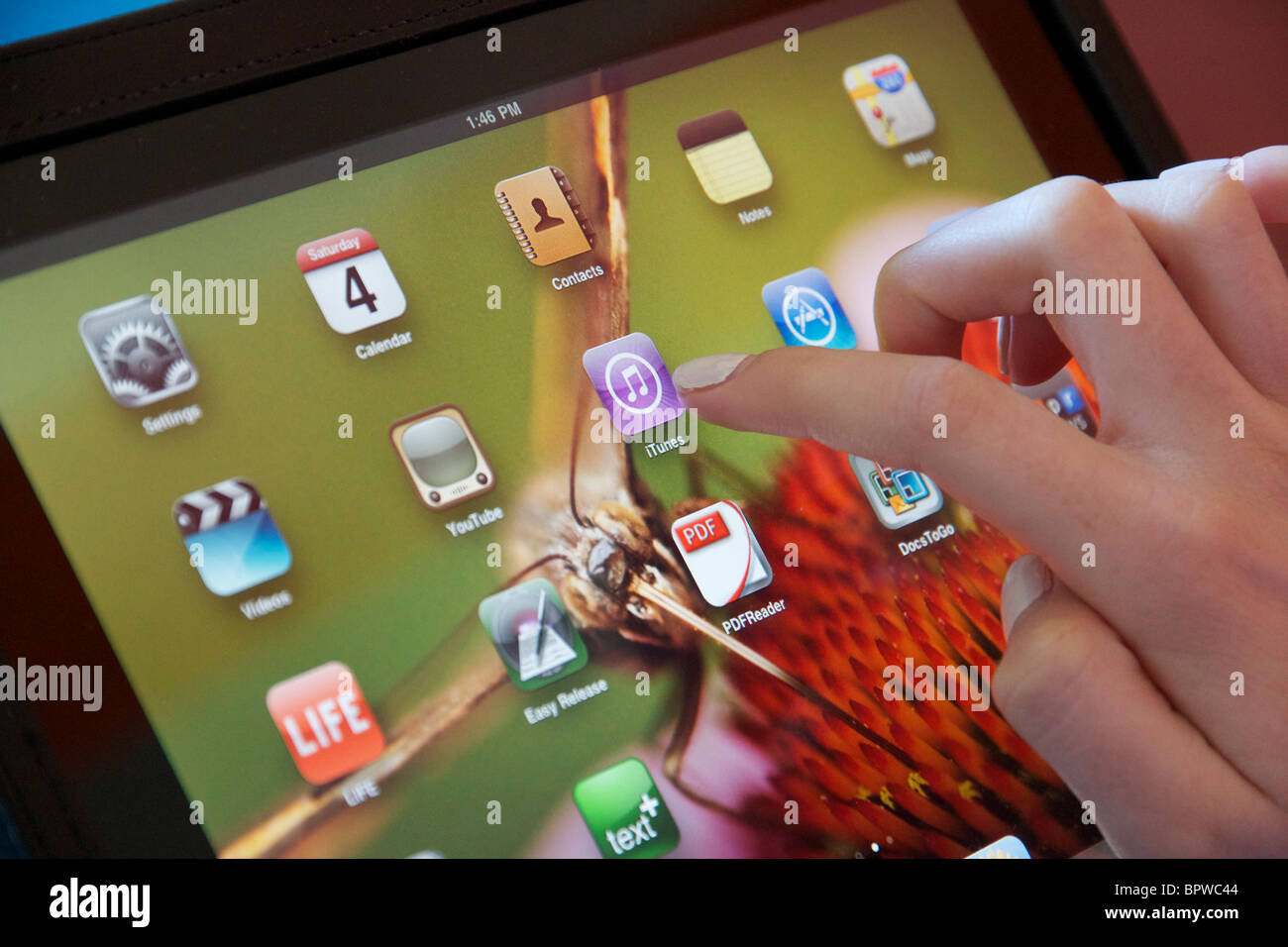 Apple iPad mit weiblichen Fingerzeig auf iTunes Symbol. Stockfoto