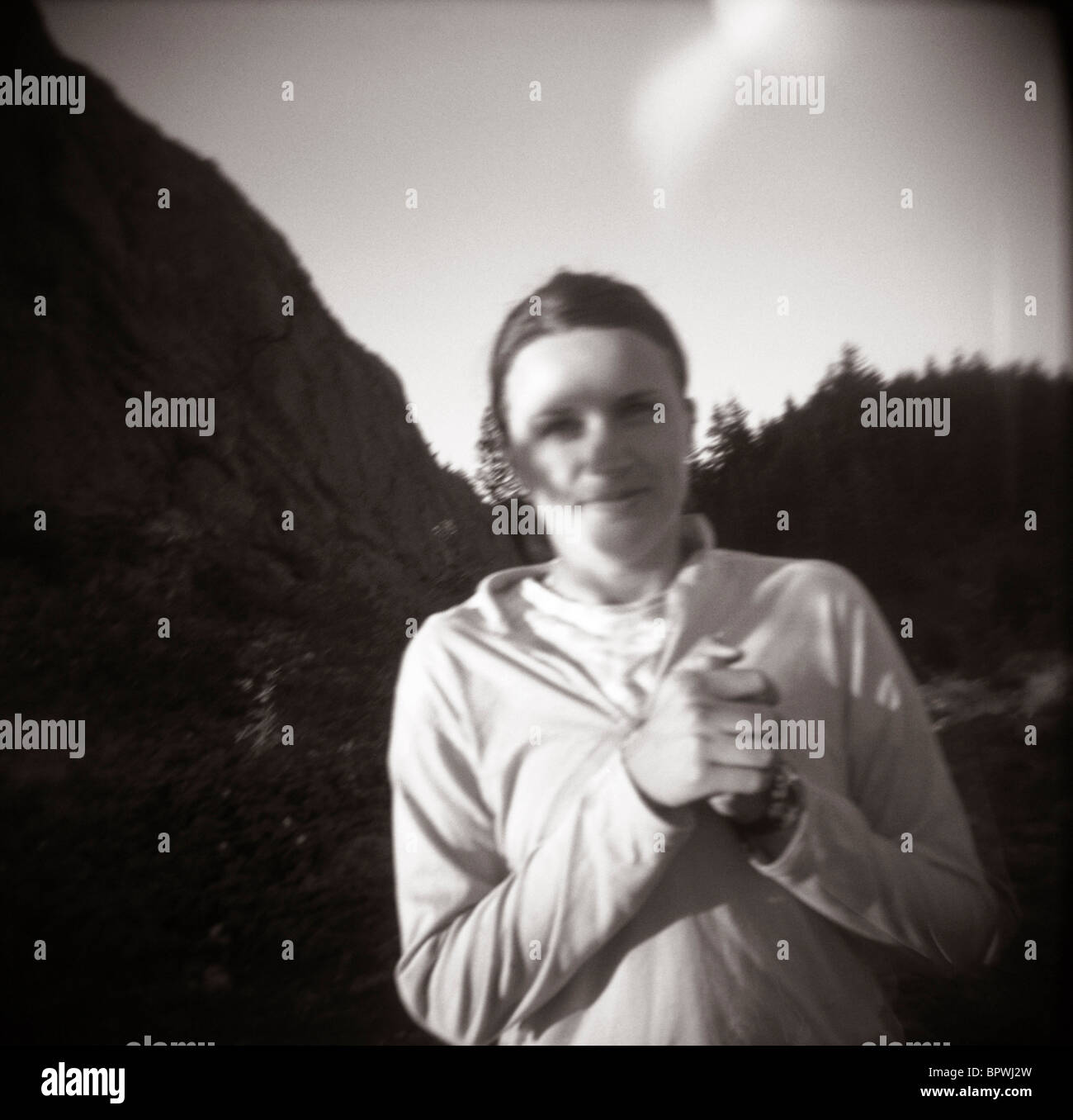 Eine junge Frau faltet ihre Hände beim Wandern. (Lochkamera) (Schwarzweiß Stockfotografie Alamy
