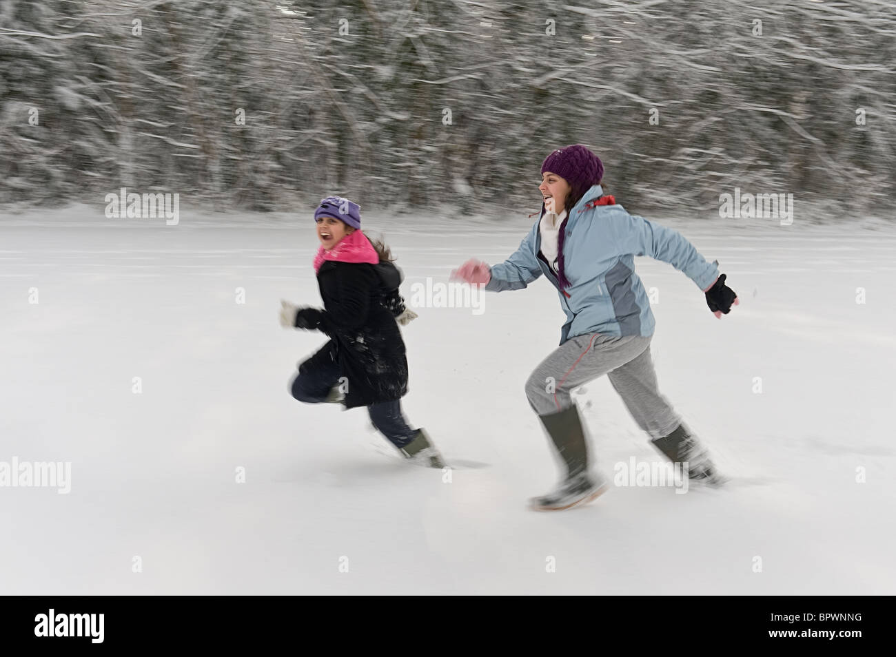 Kinder, die Spaß in der neu gefallene Schnee laufen Stockfoto