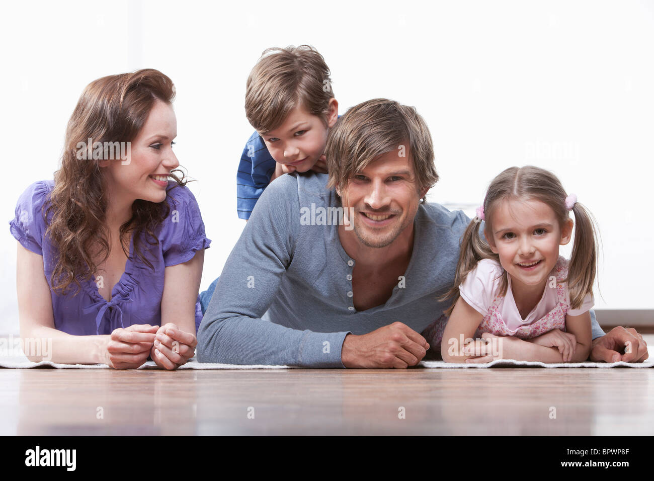 Glückliche Familie auf Teppich Stockfotografie Alamy