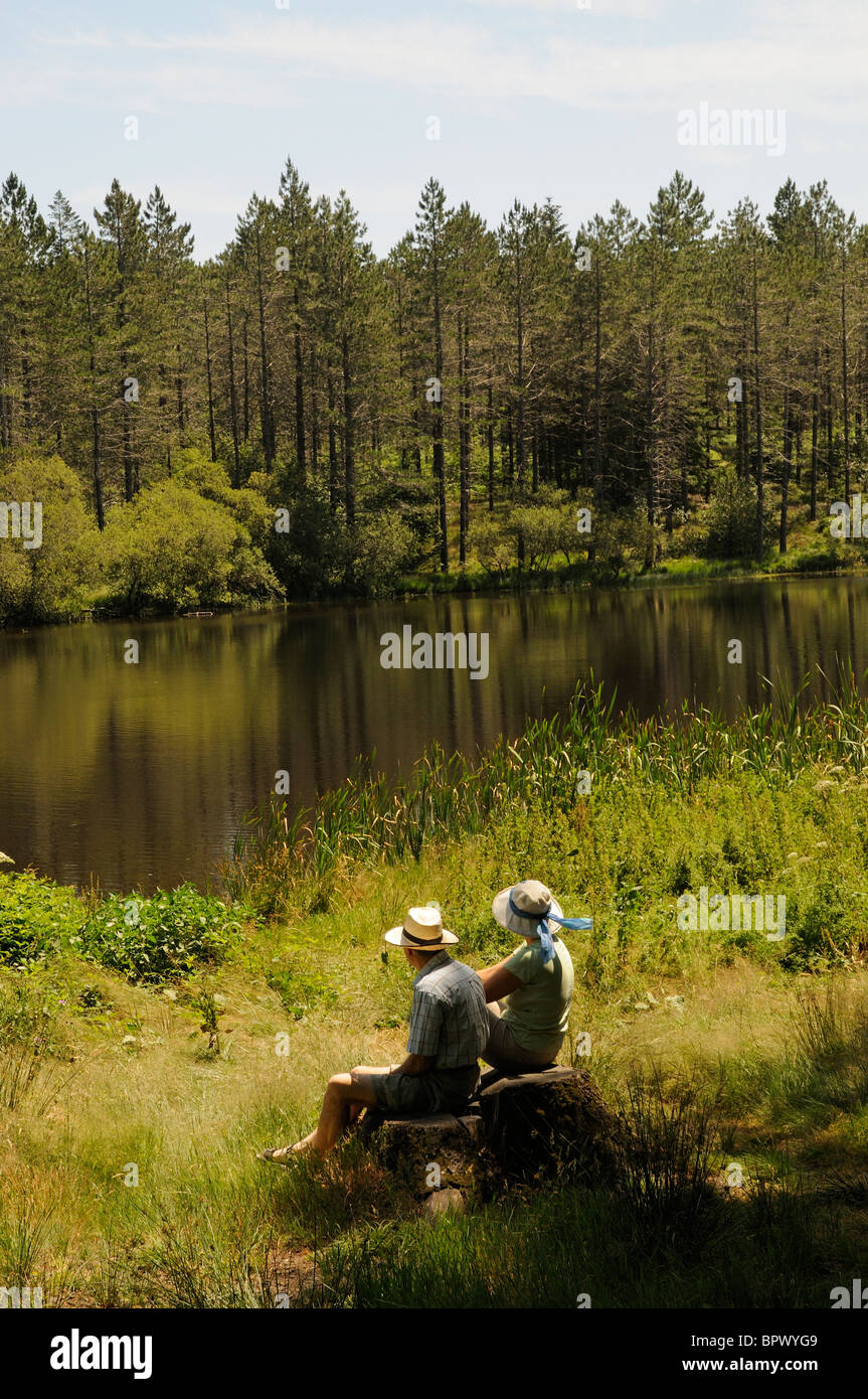 Paar sitzt am Gewässer Rand See und Kiefer Wald befindet sich auf einem Plateau in den Bergen de l' Epinouse Südfrankreich Stockfoto