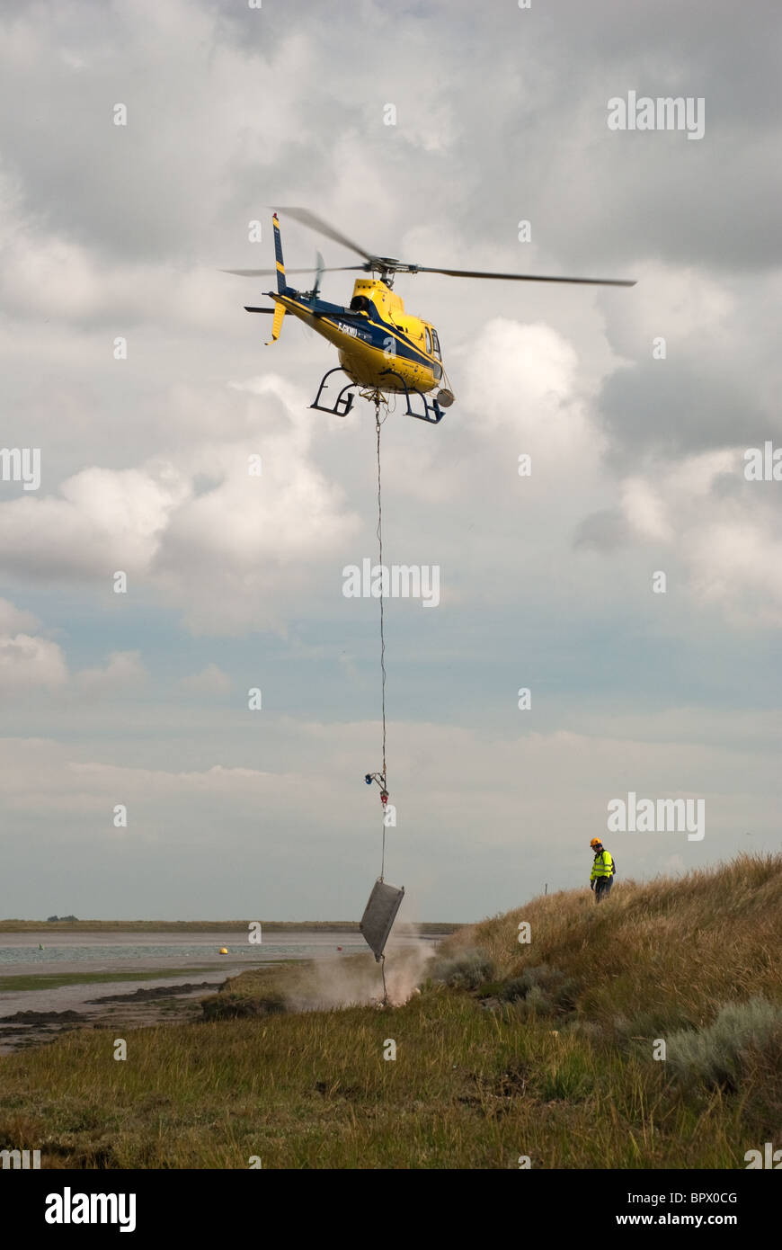 Hubschrauber mit Notfall Reparaturen an der Ufermauer auf der Fluss Roach Essex Stockfoto