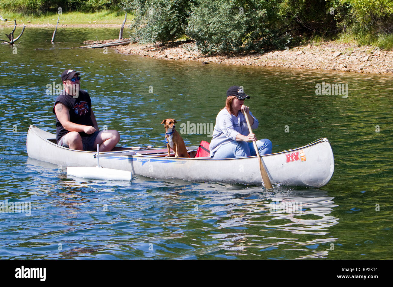 Ein Mann, Frau und ihrem Hund in einem Kanu mit Ausleger. Stockfoto