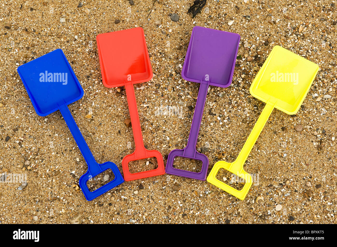 Bunte Kunststoff-Eimer und Spaten an einem Strand. Stockfoto