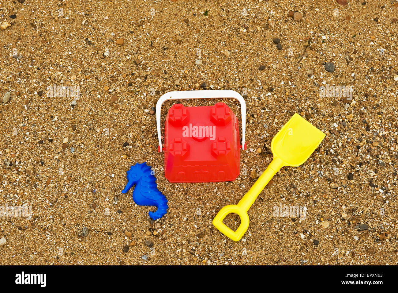 Bunte Kunststoff-Eimer und Spaten an einem Strand. Stockfoto